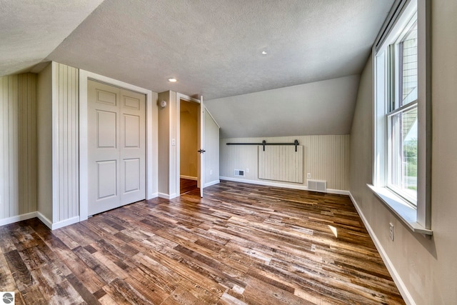 9560 S Cedar Rd, Cedar, MI 49621 - additional living space featuring wood finished floors, a textured ceiling, baseboards, vaulted ceiling, and recessed lighting