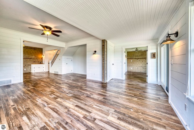 9560 S Cedar Rd, Cedar, MI 49621 - unfurnished living room with wood walls, ceiling fan, wood finished floors, and ornamental molding