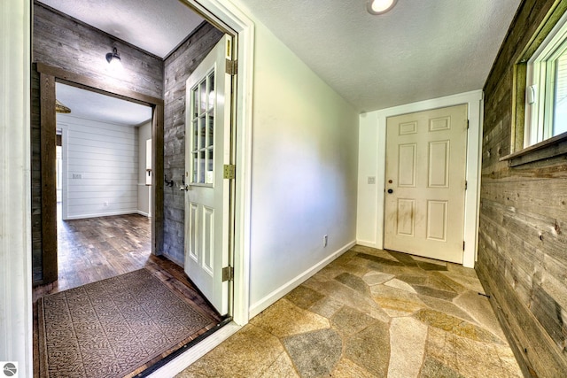 9560 S Cedar Rd, Cedar, MI 49621 - entryway with wooden walls, a textured ceiling, and baseboards