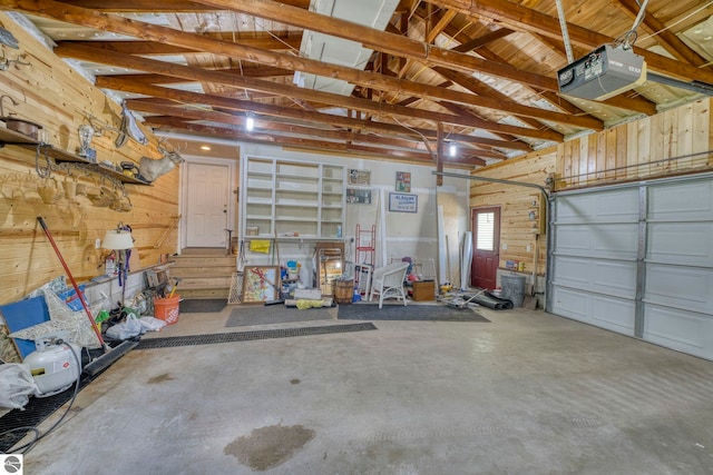 9560 S Cedar Rd, Cedar, MI 49621 - garage featuring wooden walls and a garage door opener