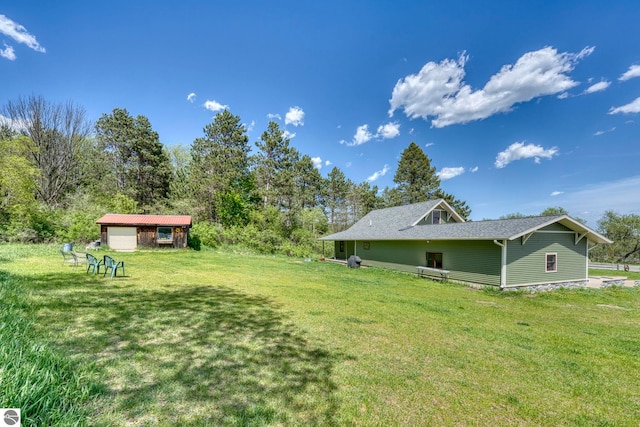 9560 S Cedar Rd, Cedar, MI 49621 - view of green lawn with an outbuilding and a garage