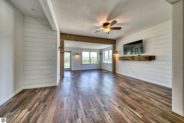9560 S Cedar Rd, Cedar, MI 49621 - unfurnished living room with wood walls, a textured ceiling, dark wood-type flooring, baseboards, and ceiling fan
