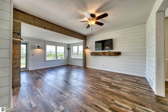 9560 S Cedar Rd, Cedar, MI 49621 - unfurnished living room featuring wood walls, a ceiling fan, dark wood-style flooring, a textured ceiling, and baseboards