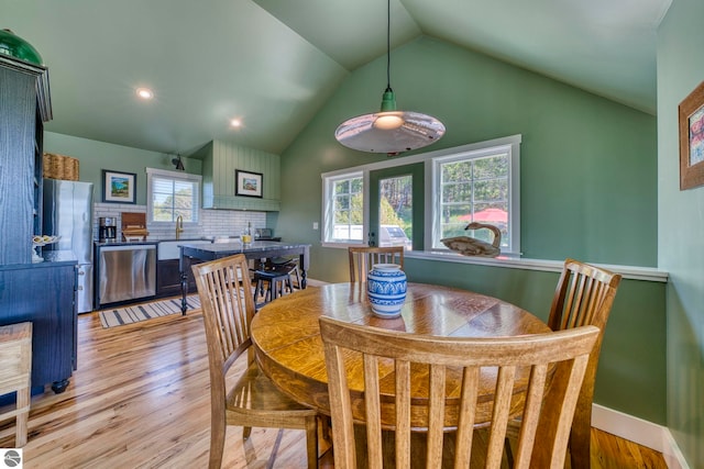 2494 N Setterbo Rd, Suttons Bay, MI 49682 - dining area with light wood finished floors, vaulted ceiling, recessed lighting, and baseboards