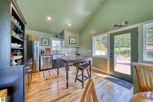 2494 N Setterbo Rd, Suttons Bay, MI 49682 - dining area featuring light wood-type flooring, high vaulted ceiling, and recessed lighting