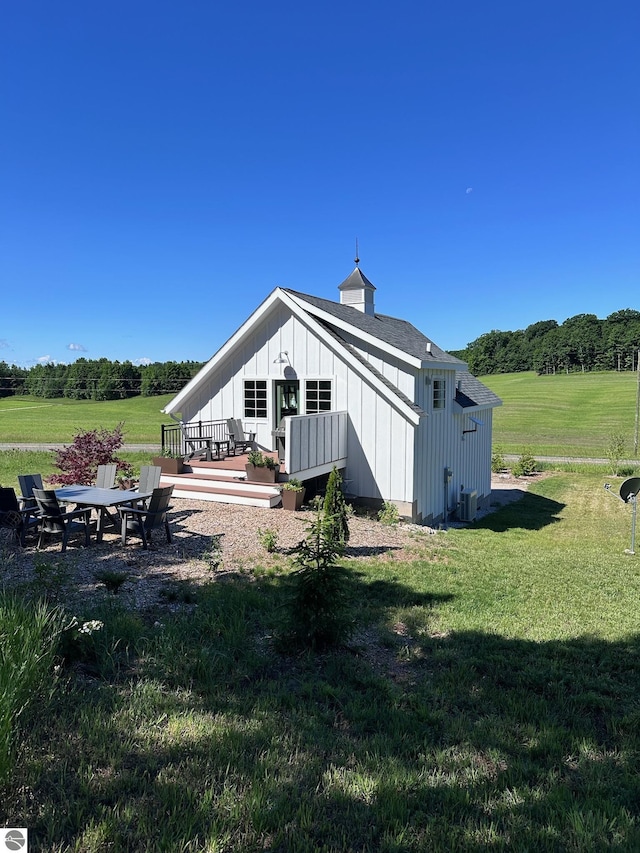 2494 N Setterbo Rd, Suttons Bay, MI 49682 - back of property featuring board and batten siding, a deck, and a lawn