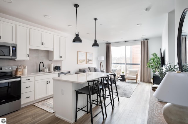 222 E State St Unit 303, Traverse City, MI 49684 - kitchen featuring appliances with stainless steel finishes, a sink, light wood-style flooring, and light countertops
