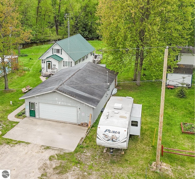 5817 Gross Dr, Weidman, MI 48893 - view of front of property with a garage, a front lawn, and a forest view