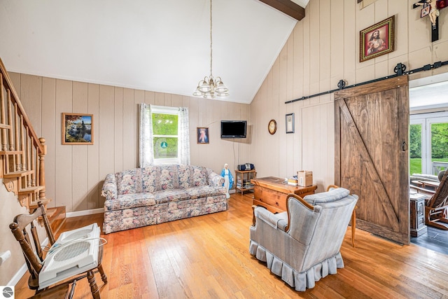 5817 Gross Dr, Weidman, MI 48893 - living area with hardwood / wood-style floors, a chandelier, stairs, a barn door, and high vaulted ceiling