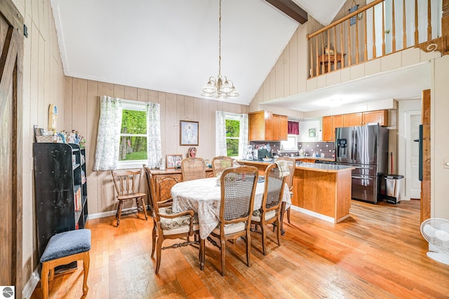 5817 Gross Dr, Weidman, MI 48893 - dining area featuring light wood-type flooring, a chandelier, high vaulted ceiling, beamed ceiling, and wooden walls