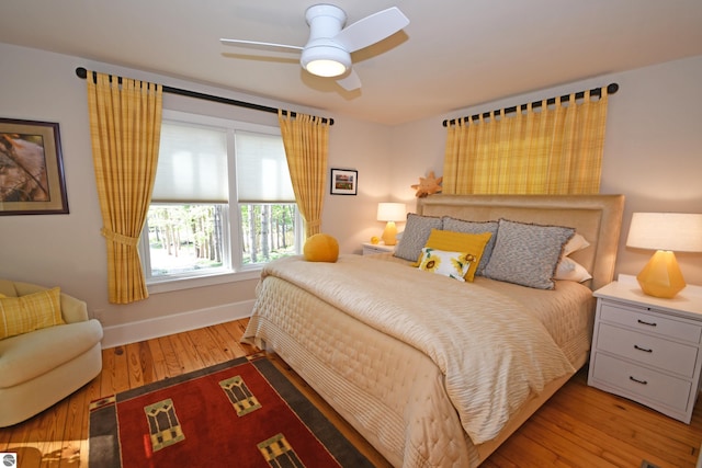 9017 S Dunns Farm Rd, Maple City, MI 49664 - bedroom with hardwood / wood-style flooring, baseboards, and ceiling fan