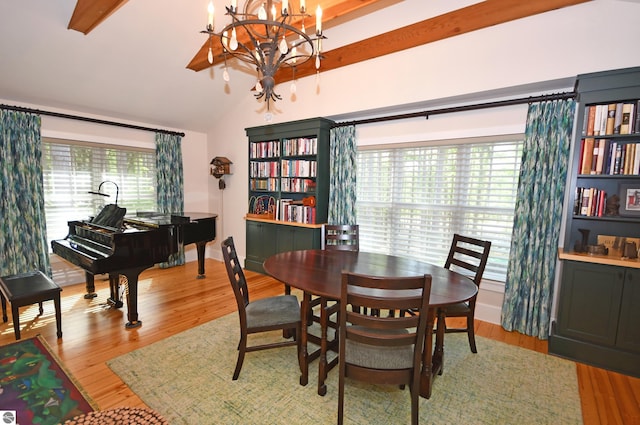 9017 S Dunns Farm Rd, Maple City, MI 49664 - dining space featuring vaulted ceiling, a chandelier, wood finished floors, and baseboards