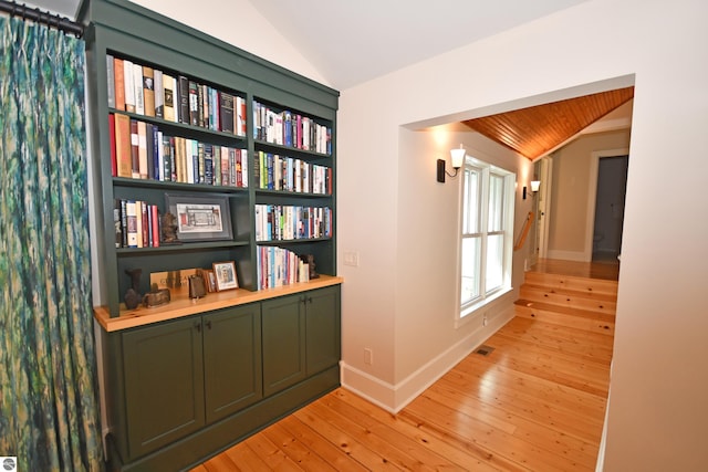 9017 S Dunns Farm Rd, Maple City, MI 49664 - corridor featuring vaulted ceiling, light wood-type flooring, and baseboards