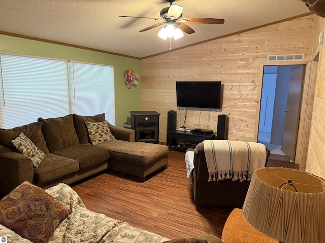 6661 Terry Ln, Hale, MI 48739 - living room featuring vaulted ceiling, wood walls, wood finished floors, ceiling fan, and ornamental molding