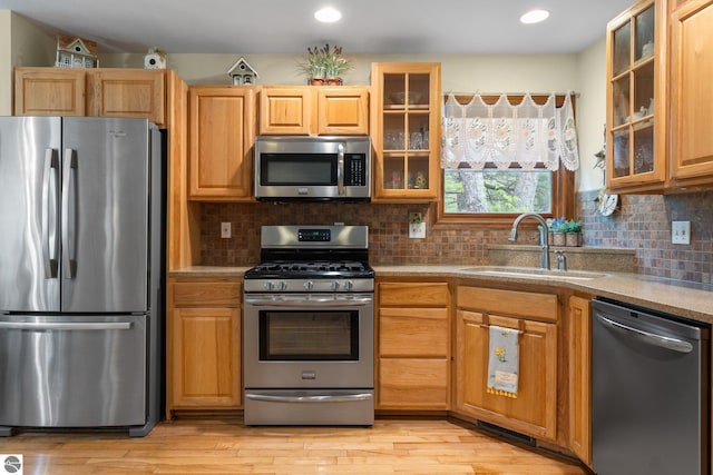 4611 Audubon Dr, Traverse City, MI 49686 - kitchen featuring stainless steel appliances, a sink, light wood finished floors, decorative backsplash, and recessed lighting