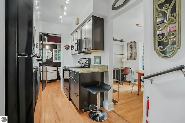 10092 S Elm St, Traverse City, MI 49684 - kitchen featuring range with electric cooktop, freestanding refrigerator, stainless steel microwave, and light wood-type flooring