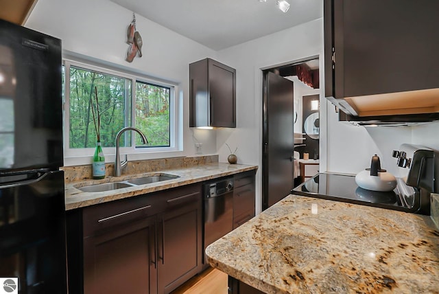 10092 S Elm St, Traverse City, MI 49684 - kitchen featuring freestanding refrigerator, a sink, dishwashing machine, light stone counters, and dark brown cabinets