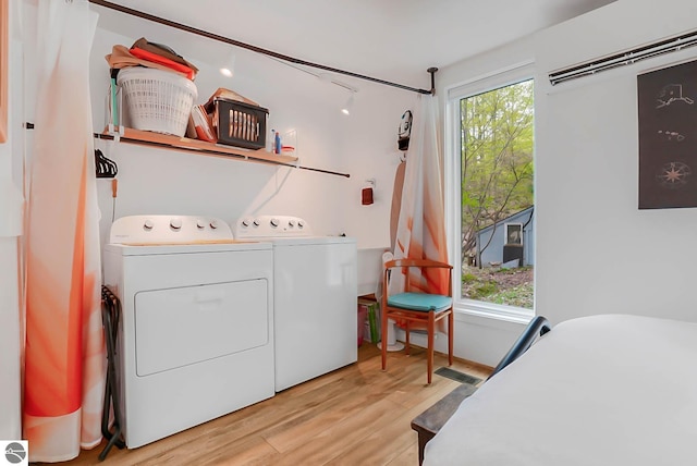 10092 S Elm St, Traverse City, MI 49684 - laundry area with a wall unit AC, separate washer and dryer, and wood finished floors