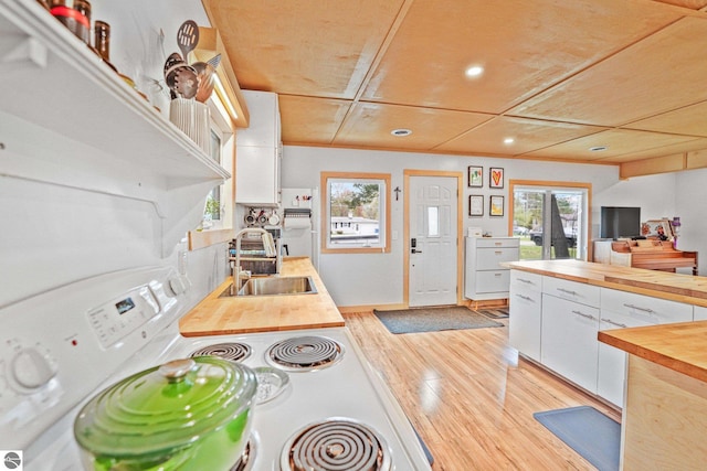 1615 Pine Dr, Traverse City, MI 49686 - kitchen with butcher block countertops, a sink, white electric range oven, white cabinetry, and recessed lighting