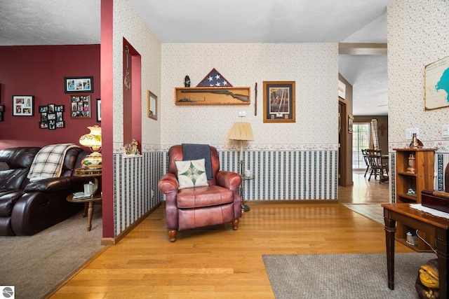 5206 S Riverview Dr, Lake City, MI 49651 - living area with wallpapered walls, wood finished floors, and baseboards