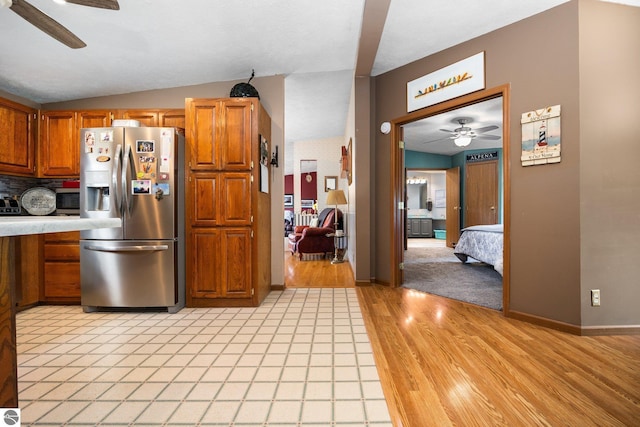5206 S Riverview Dr, Lake City, MI 49651 - kitchen with stainless steel fridge with ice dispenser, a ceiling fan, brown cabinetry, light countertops, and vaulted ceiling