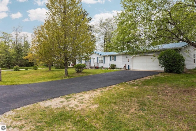5206 S Riverview Dr, Lake City, MI 49651 - view of front facade featuring driveway, a garage, and a front lawn