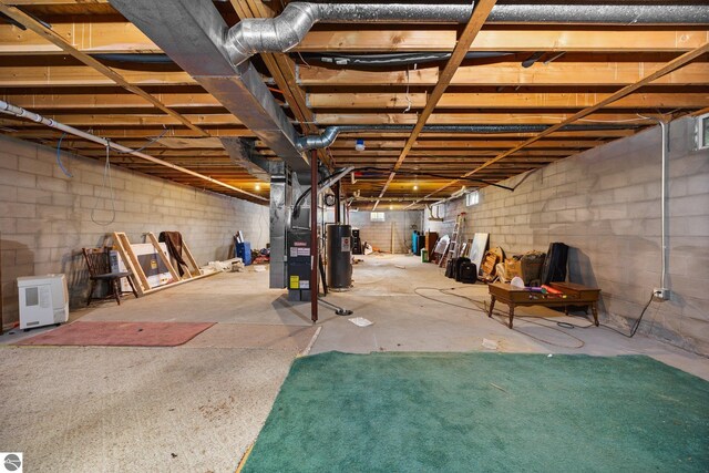 5206 S Riverview Dr, Lake City, MI 49651 - unfinished below grade area with water heater, concrete block wall, and heating unit