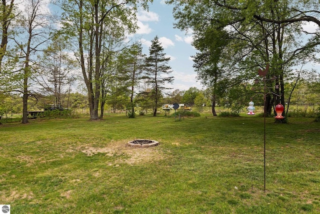 5206 S Riverview Dr, Lake City, MI 49651 - view of grassy yard with an outdoor fire pit