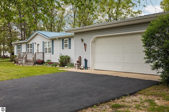 5206 S Riverview Dr, Lake City, MI 49651 - ranch-style home featuring metal roof, a garage, asphalt driveway, and a front yard