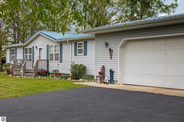 5206 S Riverview Dr, Lake City, MI 49651 - view of front of home with a front lawn, metal roof, and a garage