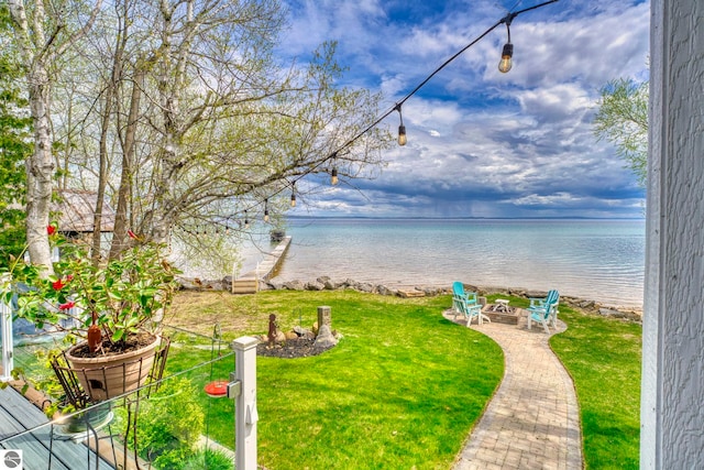 6433 S W Bayshore Dr, Traverse City, MI 49684 - view of grassy yard with a fire pit and a water view