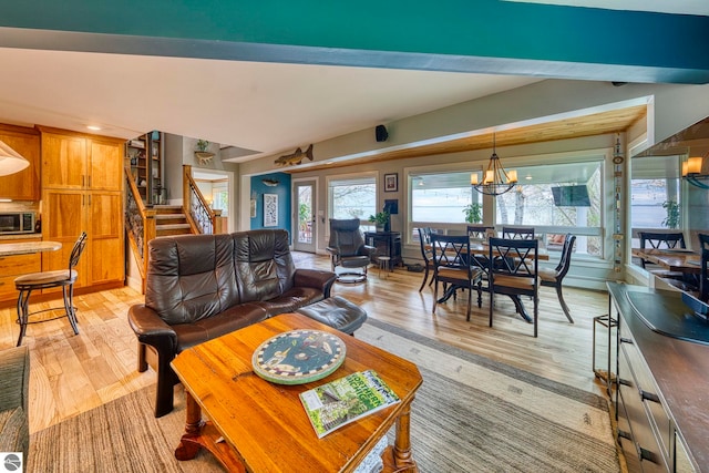 6433 S W Bayshore Dr, Traverse City, MI 49684 - living room with stairway, light wood-type flooring, plenty of natural light, and a chandelier
