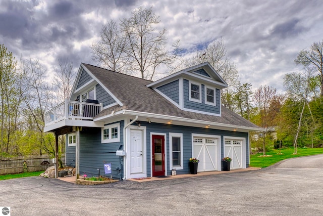 6433 S W Bayshore Dr, Traverse City, MI 49684 - view of front of property with a balcony, asphalt driveway, and a shingled roof