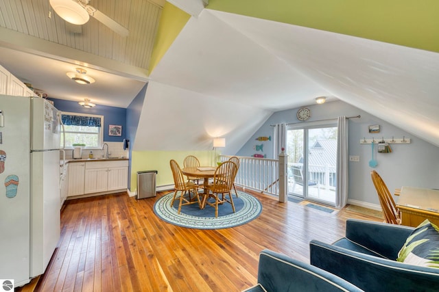 6433 S W Bayshore Dr, Traverse City, MI 49684 - dining area featuring hardwood / wood-style flooring, a baseboard heating unit, vaulted ceiling, and a ceiling fan
