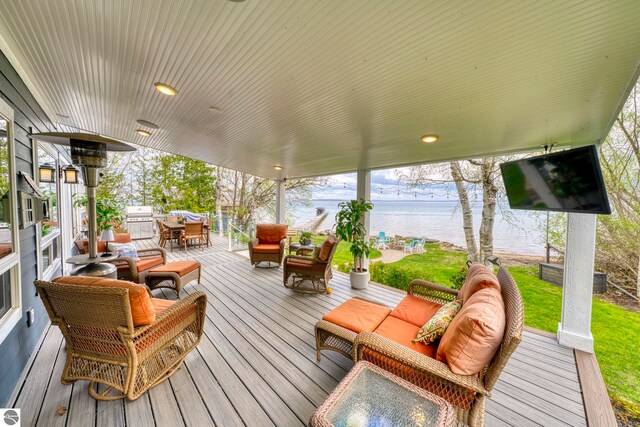 6433 S W Bayshore Dr, Traverse City, MI 49684 - wooden terrace with outdoor dining space, area for grilling, an outdoor hangout area, and a yard