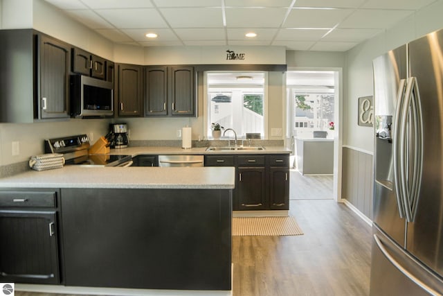 314 Leelanau Ave, Frankfort, MI 49635 - kitchen with stainless steel appliances, a sink, a paneled ceiling, wood finished floors, and light countertops