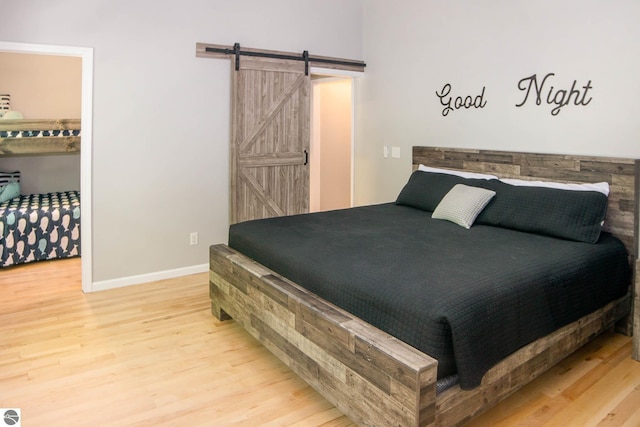 314 Leelanau Ave, Frankfort, MI 49635 - bedroom featuring wood finished floors, a barn door, baseboards, and a walk in closet