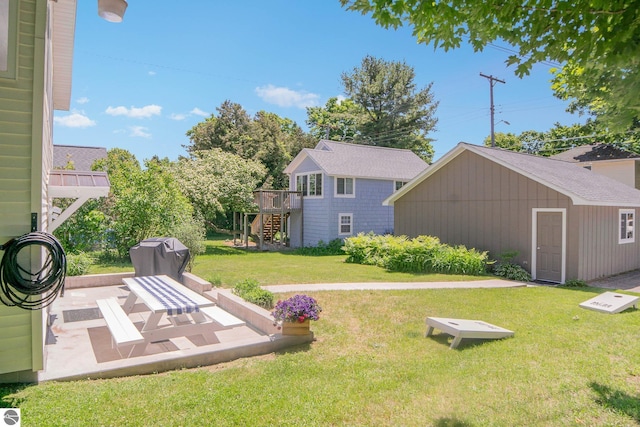 314 Leelanau Ave, Frankfort, MI 49635 - view of green lawn featuring stairs, an outbuilding, a patio, and a wooden deck