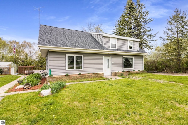 7256 Highland Dr, Beulah, MI 49617 - view of front of home with a front lawn, a shingled roof, and an outbuilding