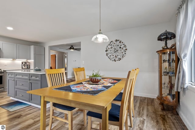 7256 Highland Dr, Beulah, MI 49617 - dining space featuring wood finished floors, wainscoting, and ceiling fan
