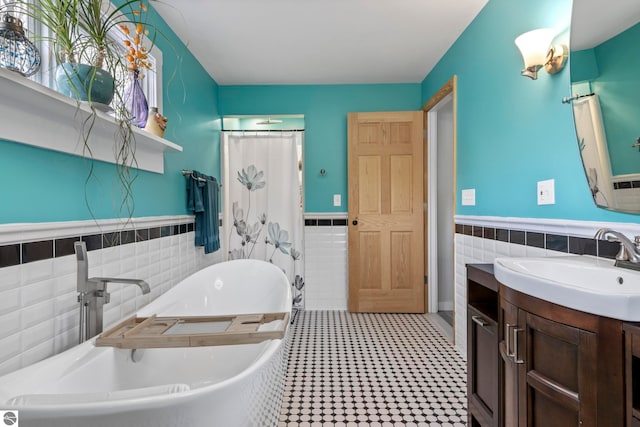 7256 Highland Dr, Beulah, MI 49617 - bathroom with tile walls, a wainscoted wall, a tub, vanity, and tile patterned floors