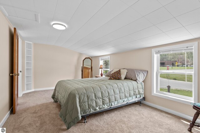 7256 Highland Dr, Beulah, MI 49617 - carpeted bedroom featuring baseboards and vaulted ceiling