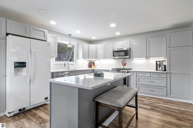 7256 Highland Dr, Beulah, MI 49617 - kitchen featuring stainless steel appliances, wood finished floors, a kitchen breakfast bar, a kitchen island, and a sink