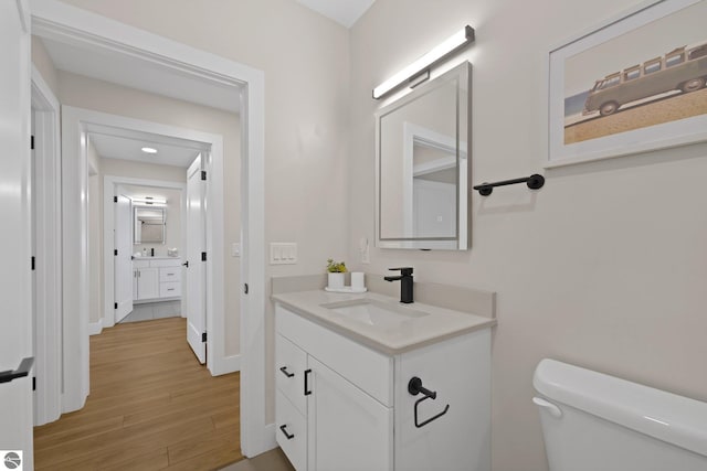 708 Randolph St Unit 204, Traverse City, MI 49684 - bathroom featuring vanity, toilet, wood finished floors, and baseboards