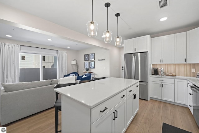 708 Randolph St Unit 204, Traverse City, MI 49684 - kitchen featuring appliances with stainless steel finishes, open floor plan, light wood-style flooring, white cabinets, and recessed lighting