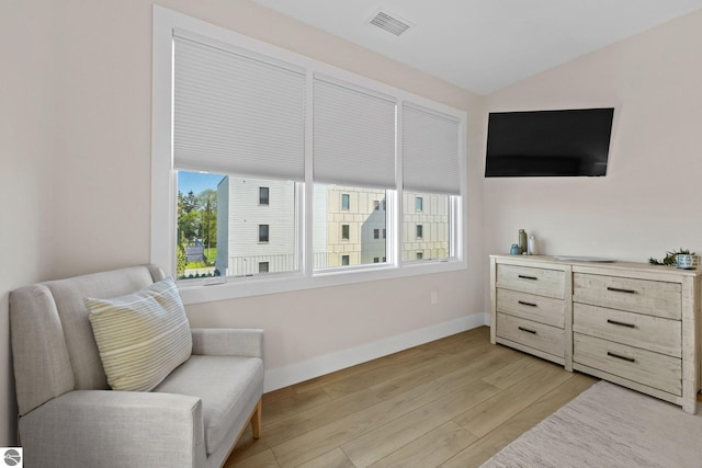 708 Randolph St Unit 204, Traverse City, MI 49684 - sitting room featuring baseboards, light wood-style floors, and vaulted ceiling