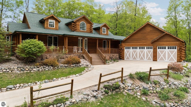 5592 Troon N, Bellaire, MI 49615 - log home with log exterior, concrete driveway, a porch, a garage, and roof with shingles