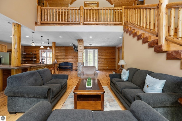 5592 Troon N, Bellaire, MI 49615 - living room featuring healthy amount of natural light, wood finished floors, a high ceiling, and stairs