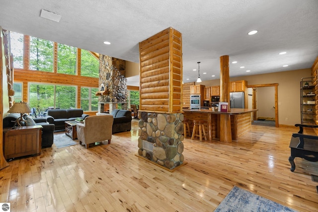 5592 Troon N, Bellaire, MI 49615 - living room with light wood-style floors, recessed lighting, a textured ceiling, a towering ceiling, and baseboards