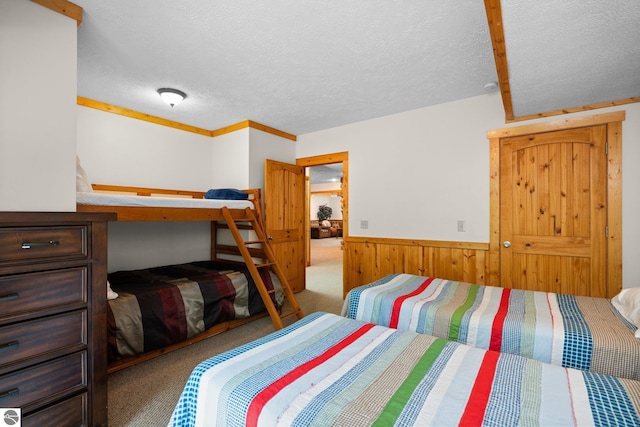 5592 Troon N, Bellaire, MI 49615 - carpeted bedroom with wainscoting, a textured ceiling, and wood walls